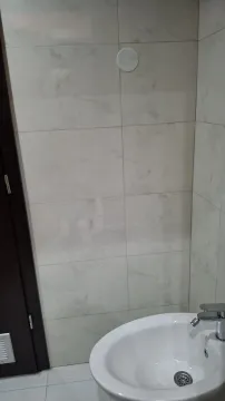 Part of a bathroom with light tiles and a sink. - image 14