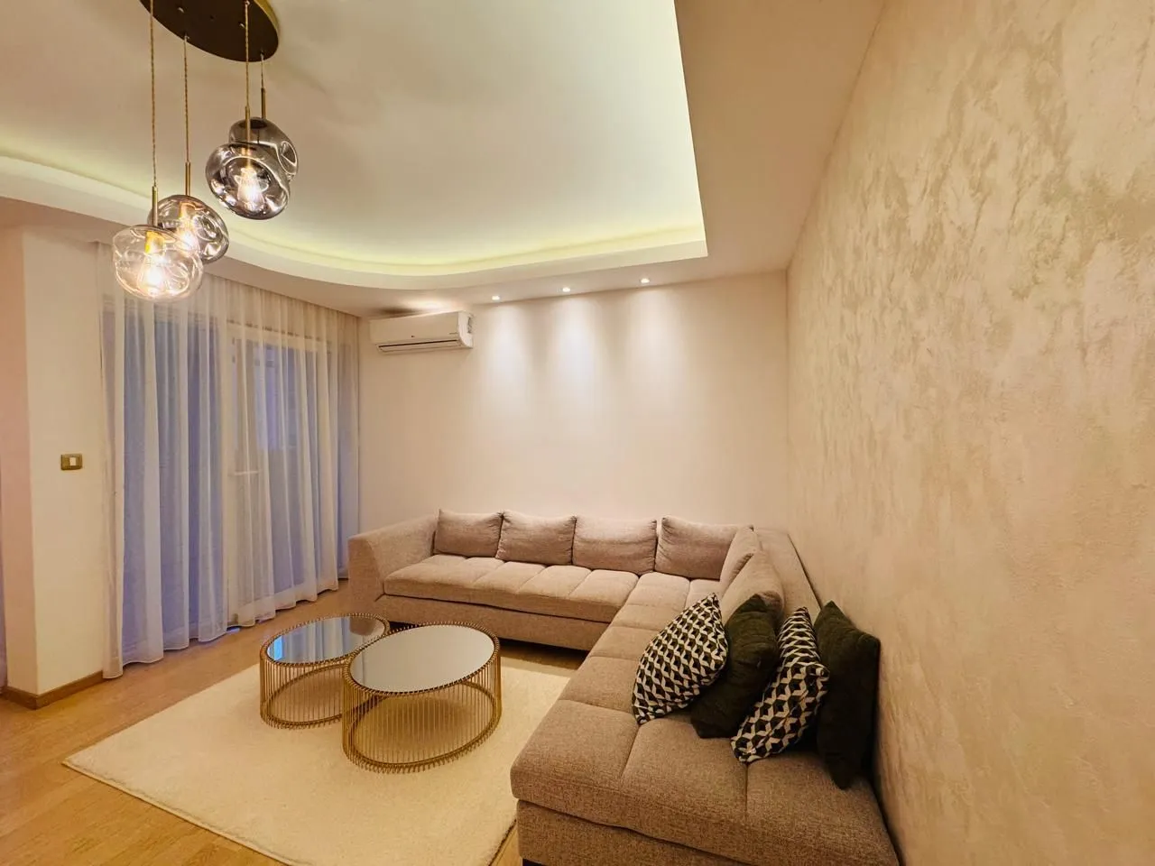 Comfortable living room with a sectional sofa and modern lighting.