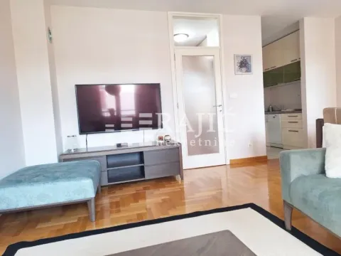 Living room with furniture and TV, overlooking the dining area and kitchen. - image 3