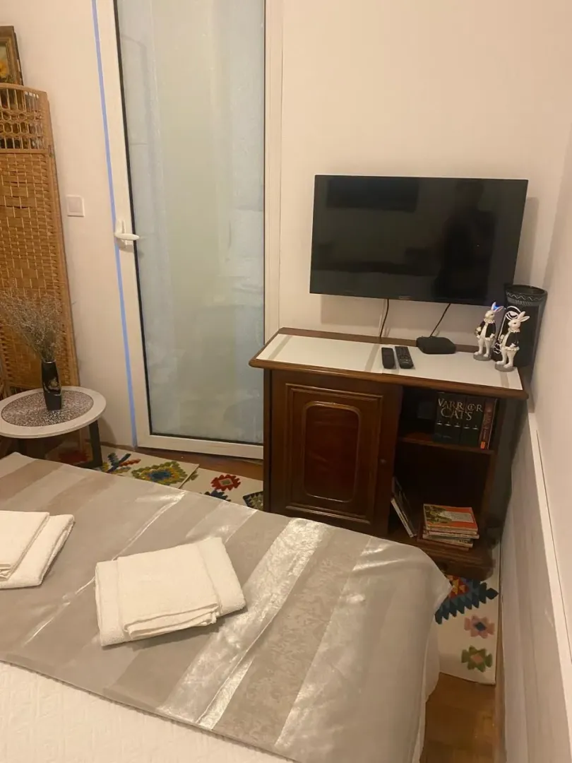 Bedroom with a bed, chest of drawers, and television.