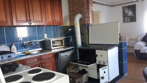 Kitchen with wooden cabinets, sink, and stove. - image 2