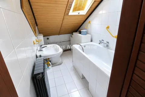 Kupatilo u potkrovlju sa kadom, umivaonikom i kosim drvenim plafonom. - image 12