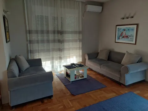 Living room with two grey sofas and wooden flooring. - image 5