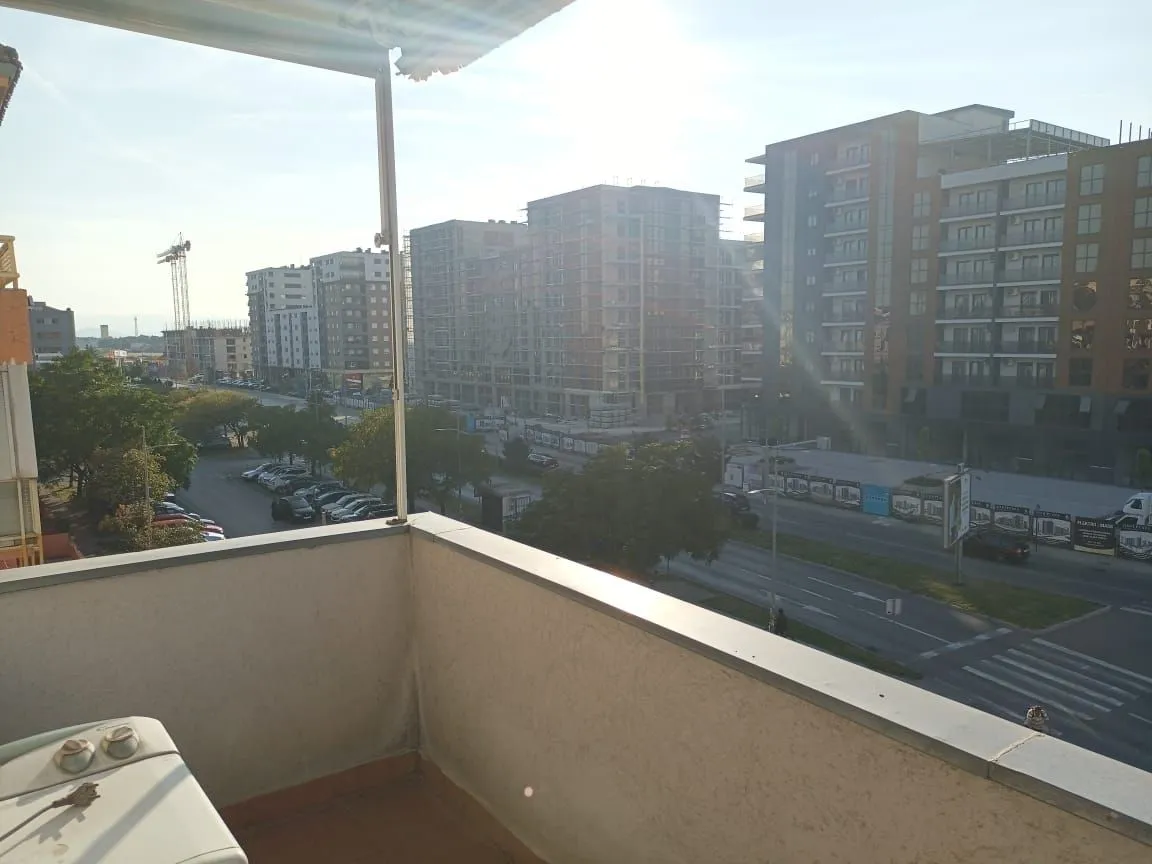 Pogled sa balkona na gradsku ulicu i okolne zgrade.