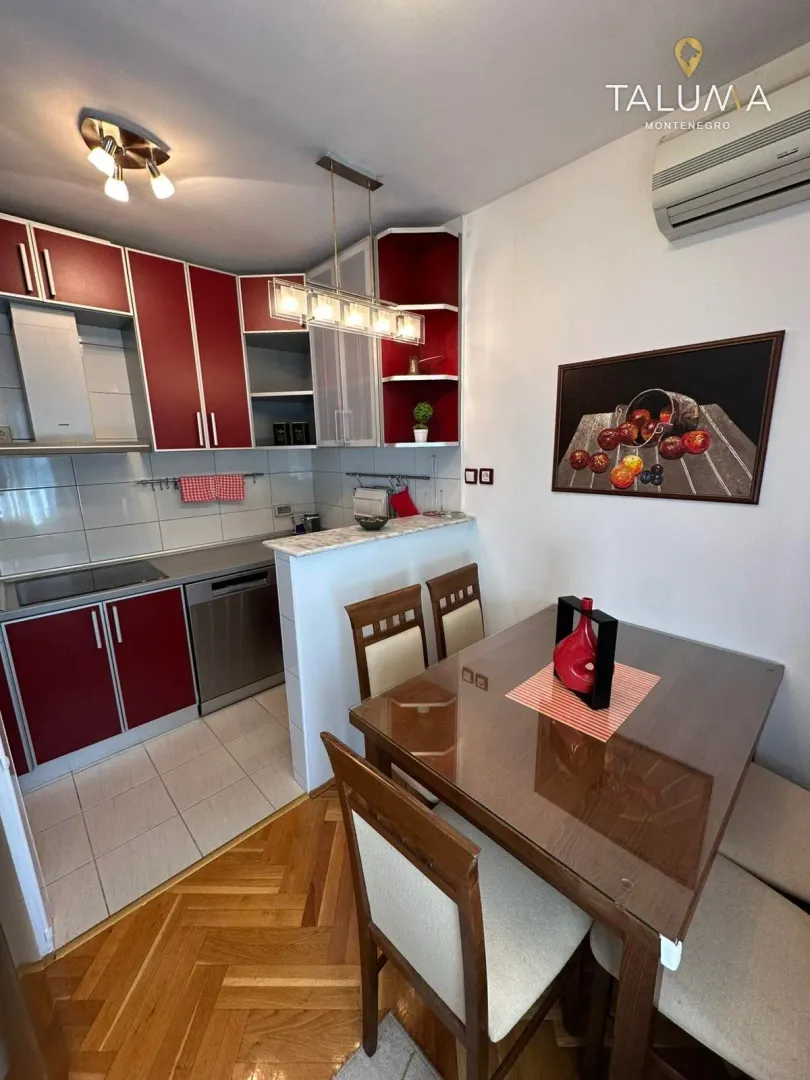 Kitchen with red cabinetry and a dining table with chairs.