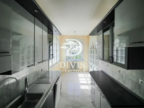 Long kitchen with dark cabinets and a large window at the end of the room. - image 13