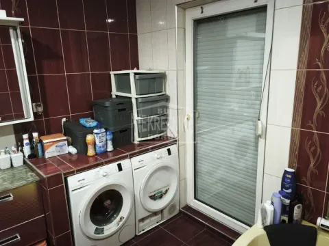 Kupatilo sa veš mašinom i keramičkim pločicama u tamnim tonovima. - image 6