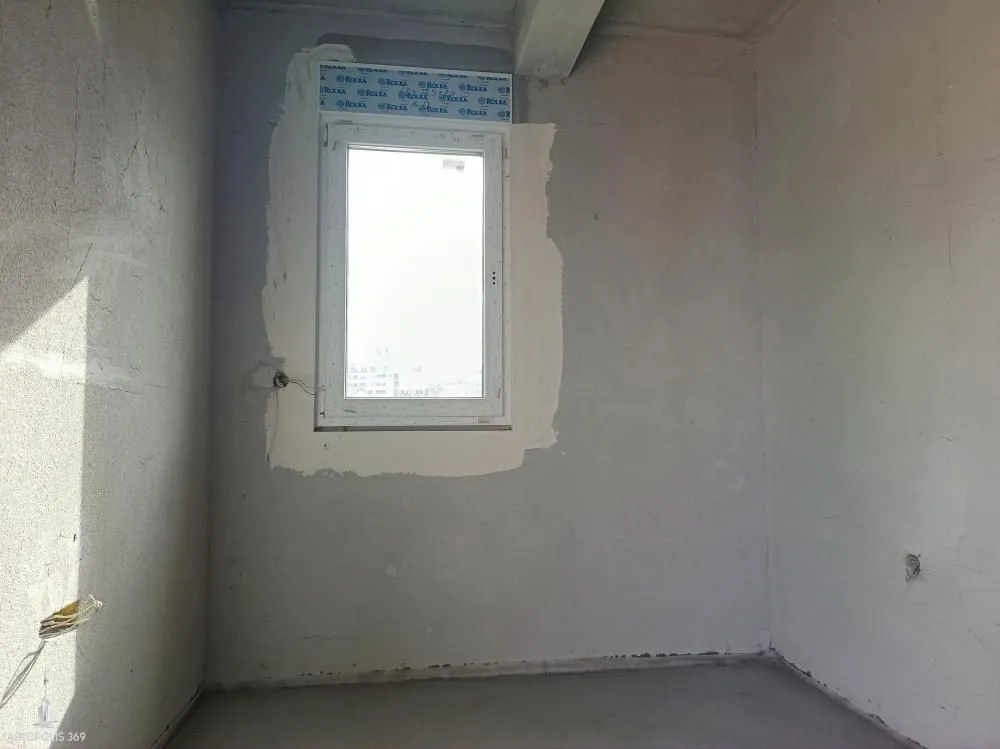 Nepotpuna prostorija u sivoj fazi sa ugrađenim prozorom.