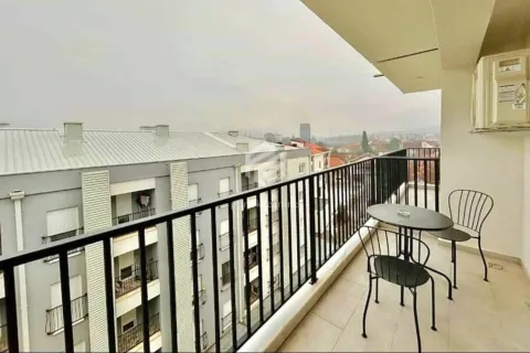 Covered balcony with patio furniture and a view of surrounding buildings. - image 2