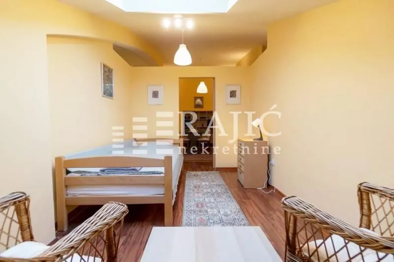 Furnished bedroom with a bed and wooden floor.