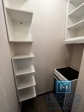 Small kitchen with white cabinets and a stove. - image 10