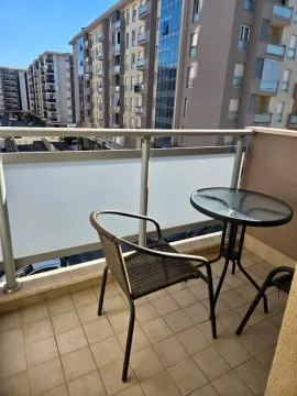 Manji namješteni balkon sa staklenim stočićem i pogledom na naselje. - image 9