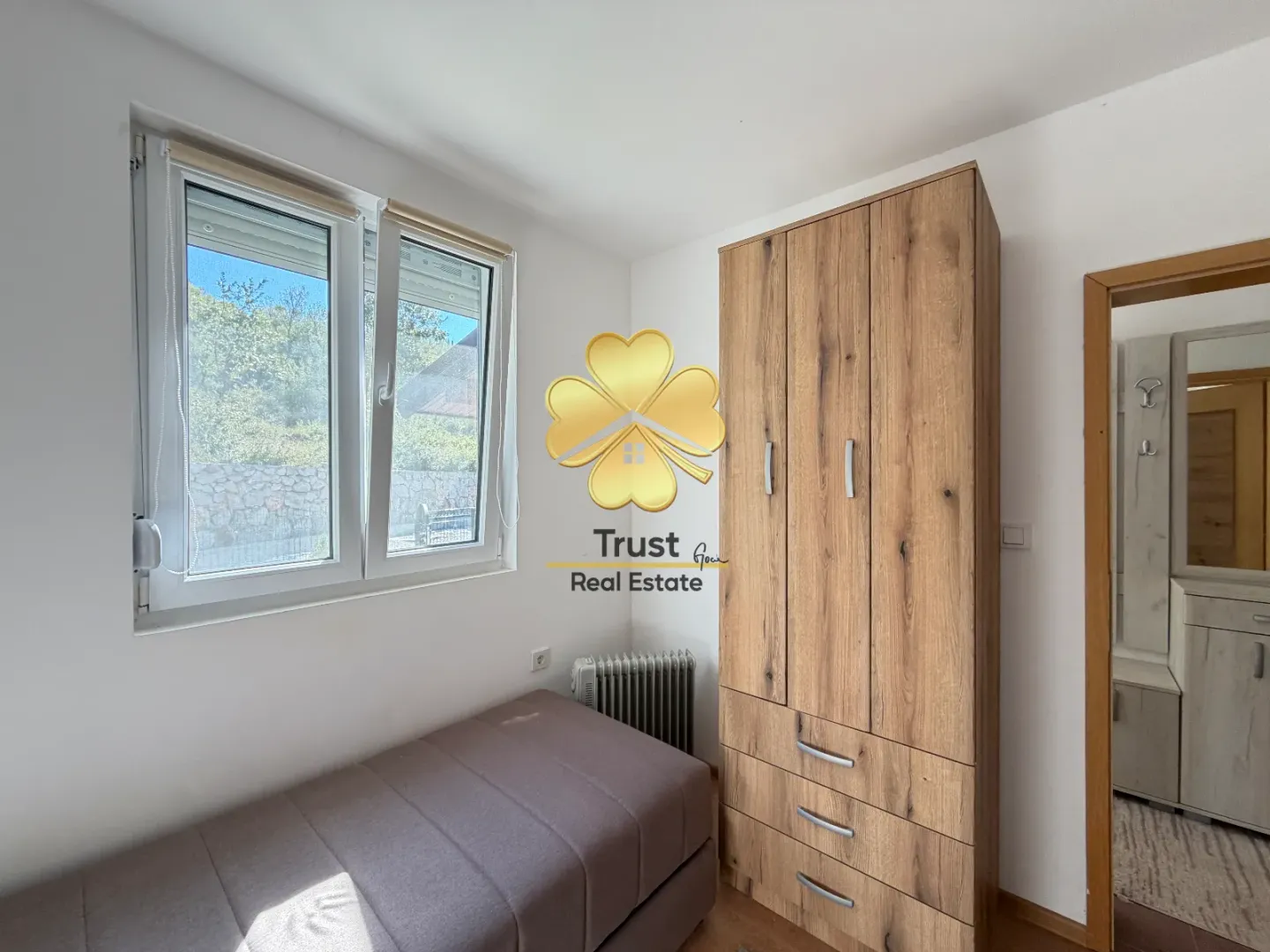 Small bedroom with a bed, wardrobe, and window.