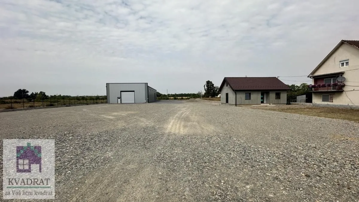 View of the spacious yard with buildings and a warehouse.