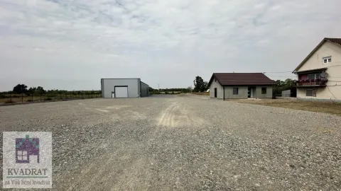 View of the spacious yard with buildings and a warehouse. - image 6
