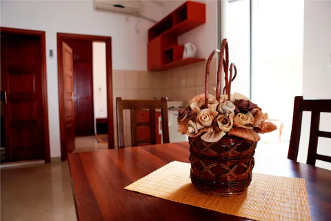 Dining table with a decorative basket and a view of the kitchen in the background. - image 4