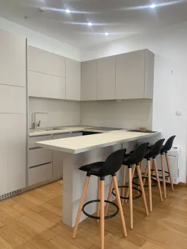 Moderna kuhinja sa šankom i drvenim stolicama. - image 8
