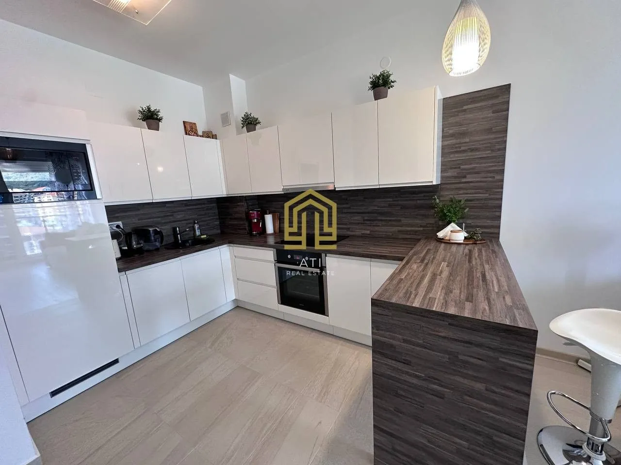 Modern kitchen with white cabinets, dark countertops and a breakfast bar.