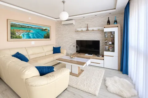 Living room with a sectional sofa, TV, and decorative elements. - image 20