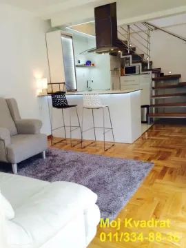 Dnevni boravak sa garniturom i šankom kuhinje u pozadini. - image 2