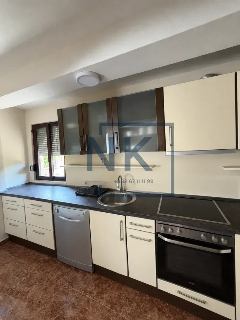 Kitchen with fitted cabinets, sink, and electric stovetop.