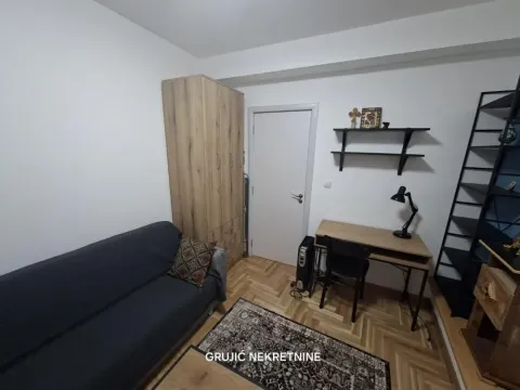 Small bedroom with a bed, desk, and wardrobe. - image 6