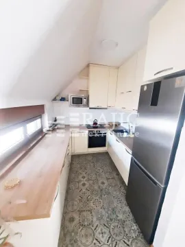Smaller kitchen with light-colored cabinetry and built-in appliances. - image 15