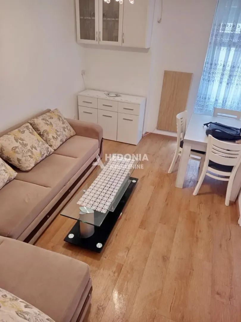 Dnevna soba sa garniturom, stočićem i trpezarijskim delom.