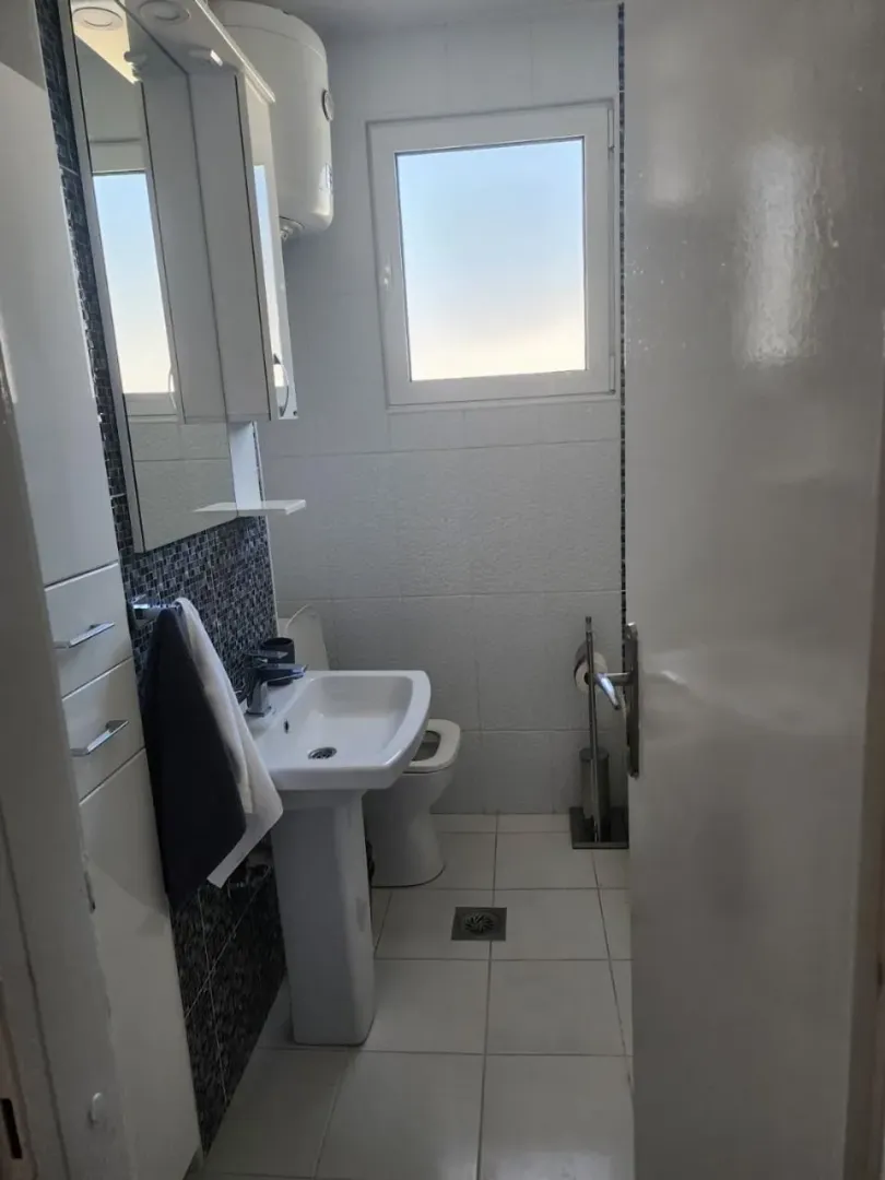 Manje kupatilo sa umivaonikom, ogledalom i WC šoljom.