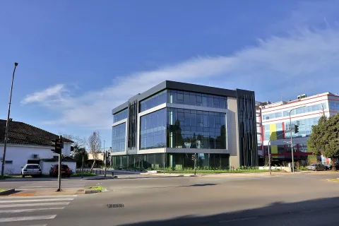 Street view of a modern commercial building with a glass facade. - image 5