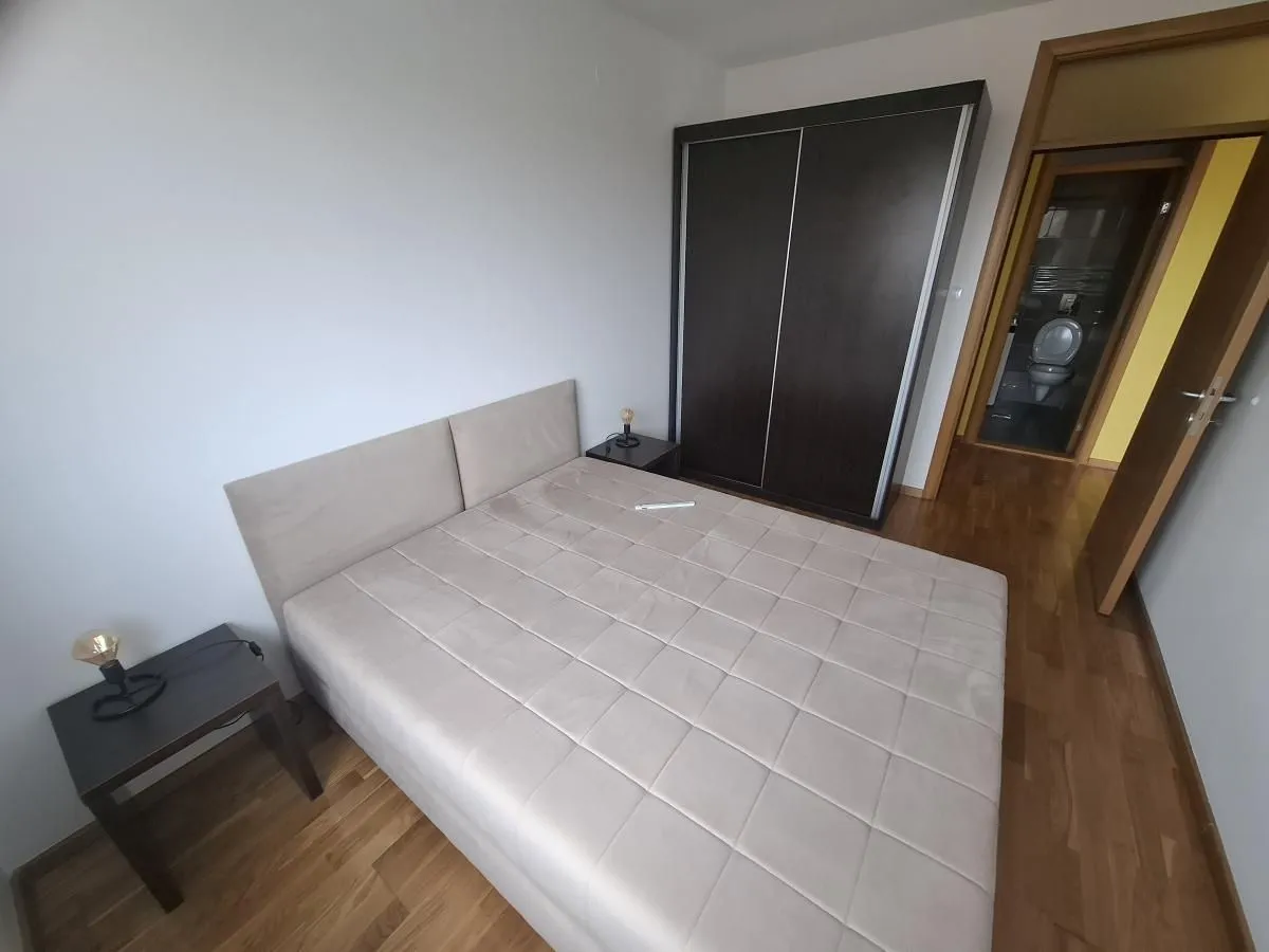 Spavaća soba sa bračnim krevetom, garderoberom i noćnim stočićima.