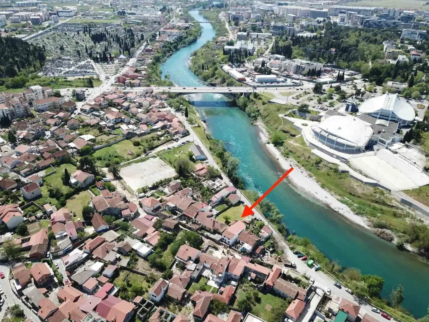 Pogled iz vazduha na naselje i rijeku sa označenom lokacijom nekretnine.
