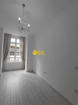 Empty room with white walls, a window, and a chandelier. - image 5