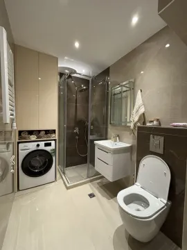 Moderne kupatilo sa tuš kabinom, umivaonikom, WC šoljom i ugrađenom veš mašinom. - image 5