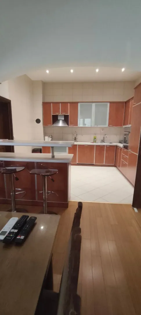Spacious kitchen with wooden cabinets and a breakfast bar connected to the dining area.