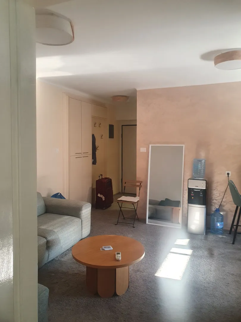 Dnevni boravak sa garniturom, stočićem i pogledom prema predsoblju.