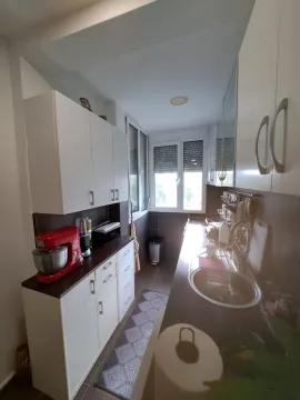 Manja kuhinja sa bijelim elementima i prozorom na kraju. - image 11