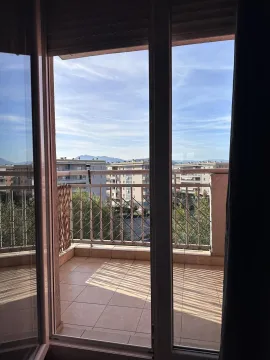 View of the city and mountains from a balcony through open doors. - image 4