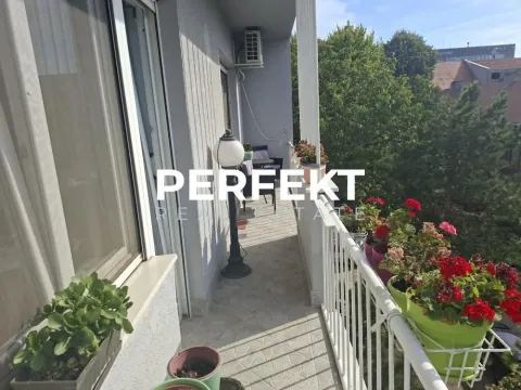 Natkriveni balkon sa saksijama cveća i pogledom na zelenilo. - image 3