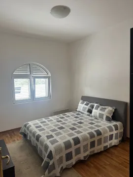Bright bedroom with a double bed and an arched window. - image 4
