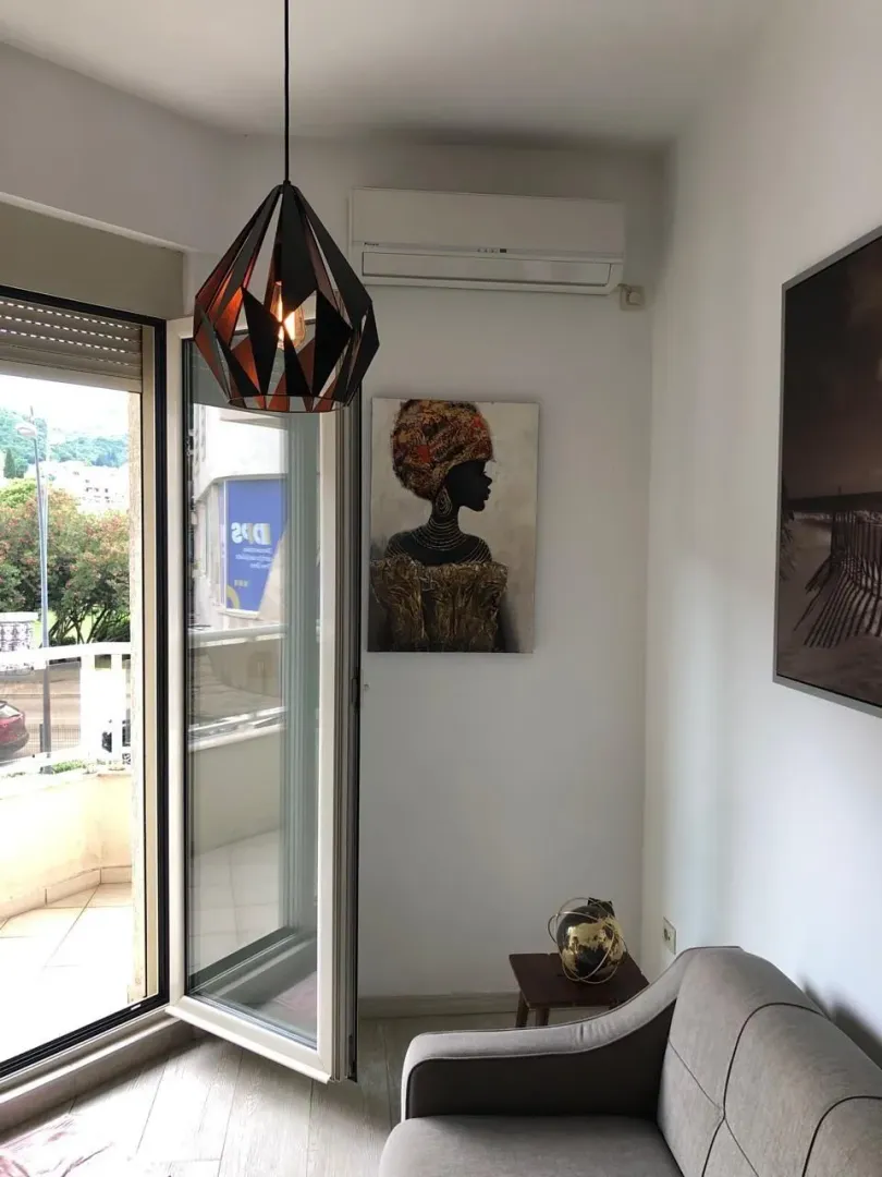Living room with a sofa, wall art, and access to the terrace.