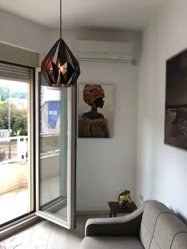 Living room with a sofa, wall art, and access to the terrace. - image 17