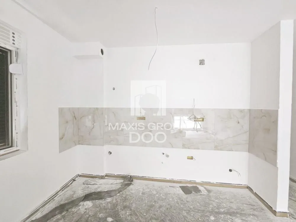 Empty space under construction with wall tiles installed for a kitchen.