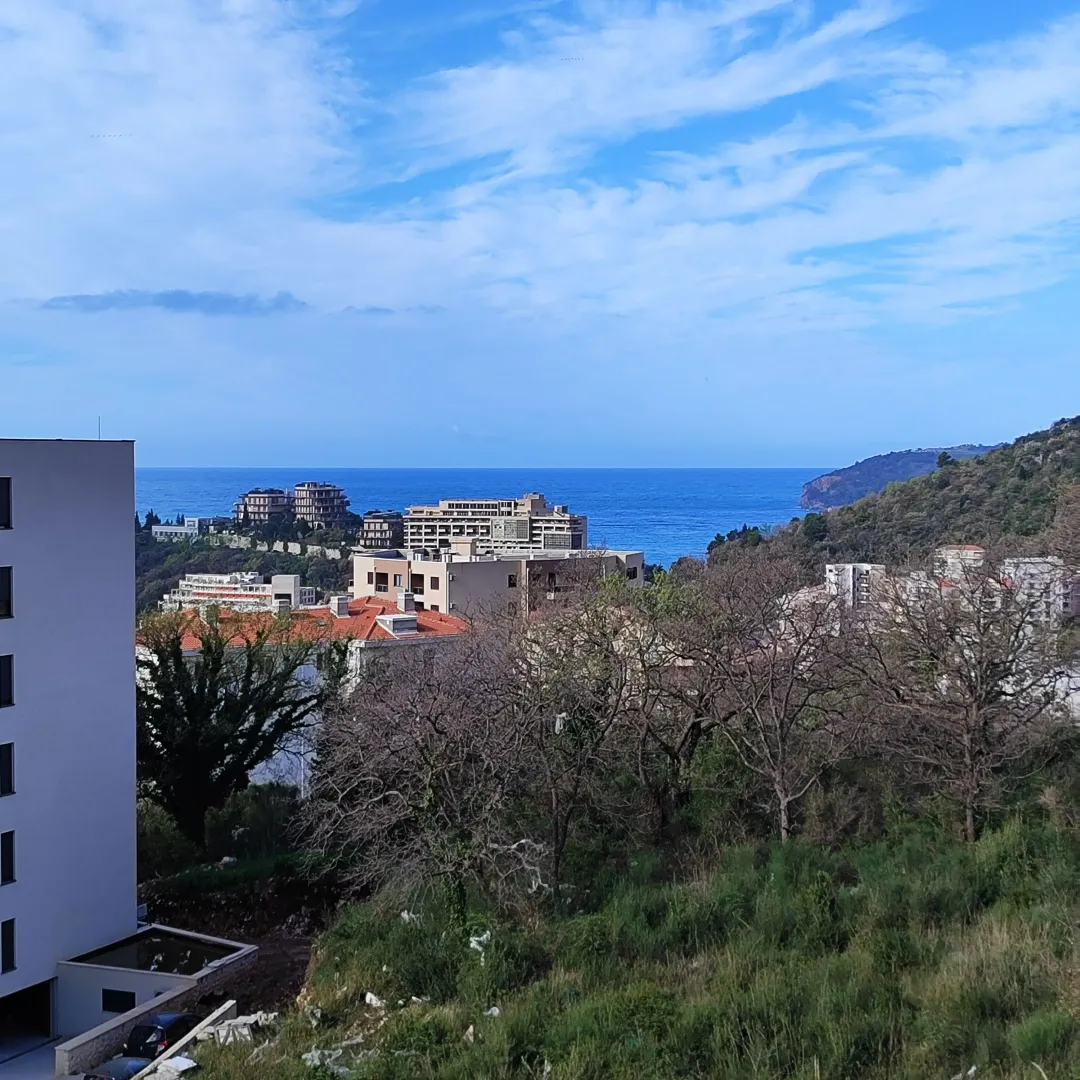 Pogled na more i okolne zgrade sa terase nekretnine.