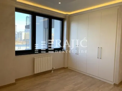 Bright bedroom with a large window and built-in wardrobe. - image 8