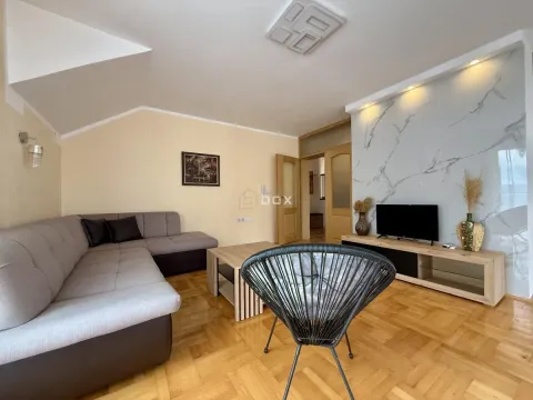 Living room with a sofa, TV, and parquet flooring. - image 2