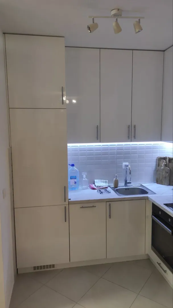 Small kitchen with white units and a built-in oven.