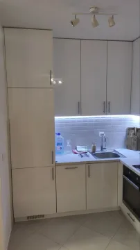 Small kitchen with white units and a built-in oven. - image 11
