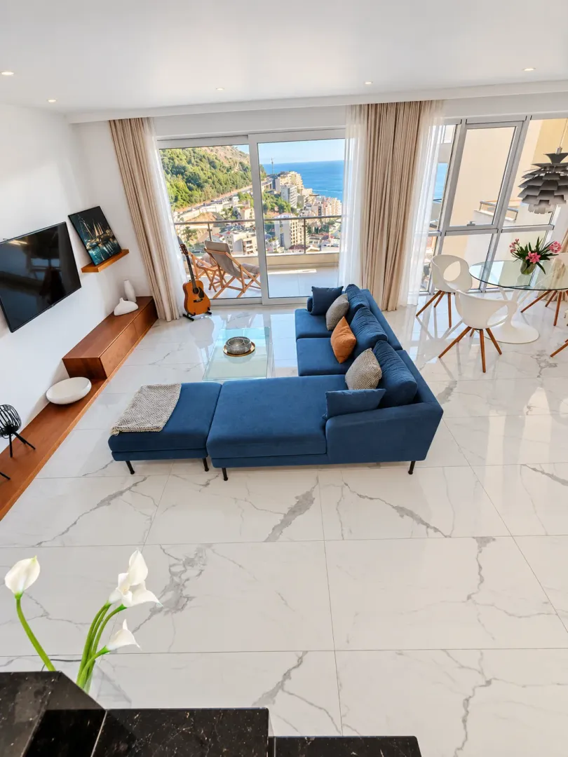 Spacious living room with a blue sectional sofa and sea view.