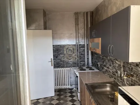 Small kitchen with a sink, stove, and upper cabinets. - image 13